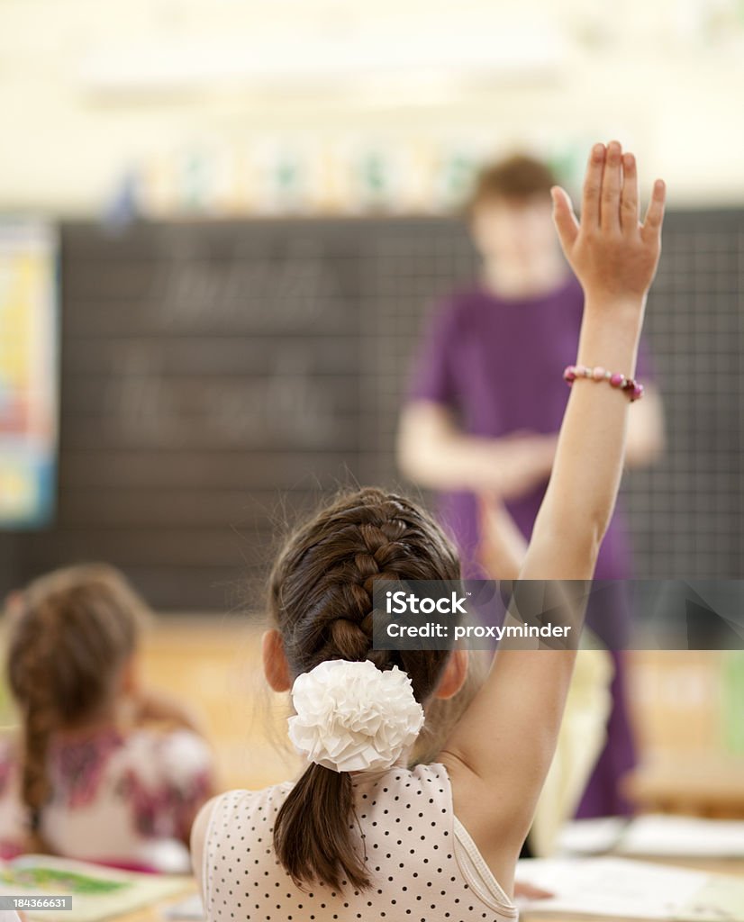 Elevar las manos en elemental con montaje tipo aula - Foto de stock de Alzar la mano libre de derechos