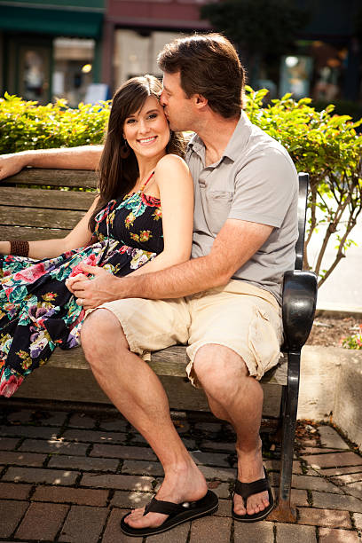 istock Happy Young Couple Sitting on Bench Downtown 184366633