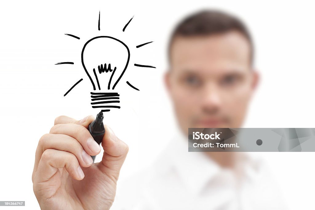 Blurred businessman drawing a lightbulb showing an idea Businessman drawing a bulb on a virtual whiteboard. Metaphor for Ideas and Inspiration. Light Bulb Stock Photo