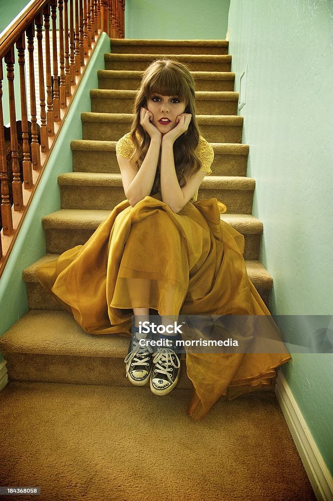 Teen Girl With Formal Prom Gown and Sneakers Teen girl sits on staircase wearing her formal prom gown and her ratty, old sneakers Canvas Shoe Stock Photo