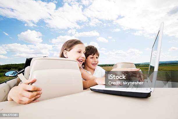 Jungen Und Mädchen Sitzt In Cabrio Auto Mit Laptop Stockfoto und mehr Bilder von Alles hinter sich lassen