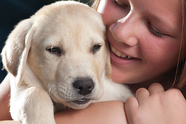 istock Little girl cuddling a puppy 184370646