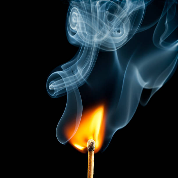 istock Ignition of match, with smoke on black 184371081