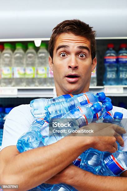 Człowiek Kupując Butelki Bulk - zdjęcia stockowe i więcej obrazów Woda butelkowana - Woda butelkowana, Nosić, Supermarket