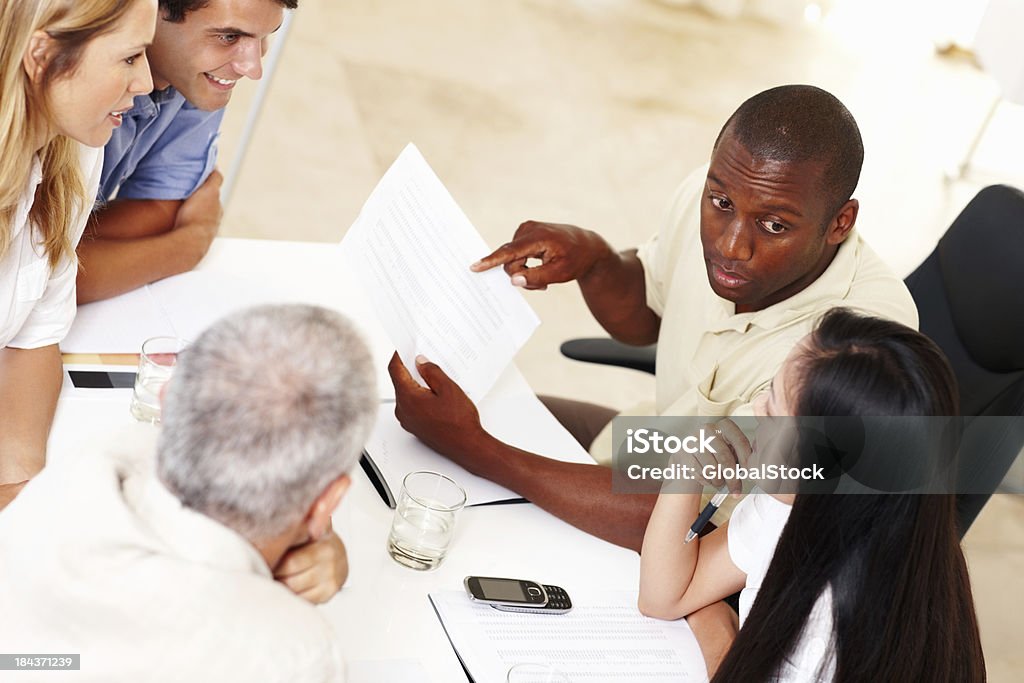 Multi étnico ejecutivos discutiendo documento - Foto de stock de 30-39 años libre de derechos