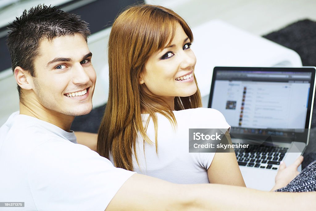 Bella giovane coppia utilizzando un computer portatile. - Foto stock royalty-free di Adulto