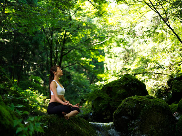 frau tun yoga in der natur - natural phenomenon waterfall rock tranquil scene stock-fotos und bilder