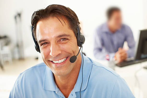 istock A smiling customer service assistant at his desk 184372128