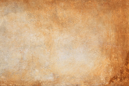 A wall in Rome.  Only a small part of the wall is shown.  The wall is orange and is more whitish in the center.  The right part of the picture is the most orange.  The orange color is mixed with shades of brown.