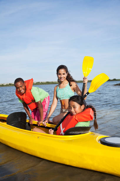 nastoletnie dziewczyny pomagają dzieciom z kajak - summer camp child teenager kayak zdjęcia i obrazy z banku zdjęć