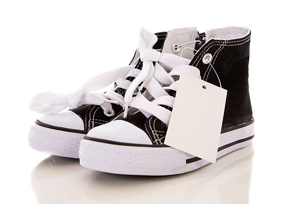 shoes hanging from laces on wood surface