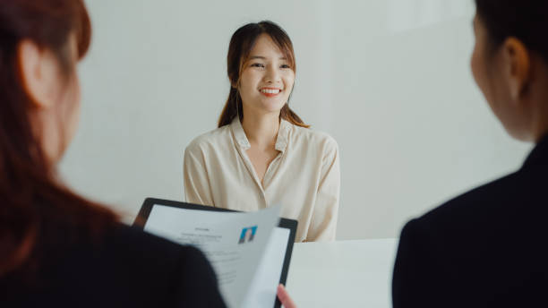 młoda azjatka przechodzi rozmowę kwalifikacyjną przed menedżerem hr w biurze. zasoby ludzkie, agencja rekrutacyjna. - discussion interview talking place of work zdjęcia i obrazy z banku zdjęć