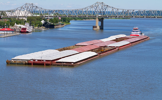 A river barge transporting grain and scrap materials to be processed. 