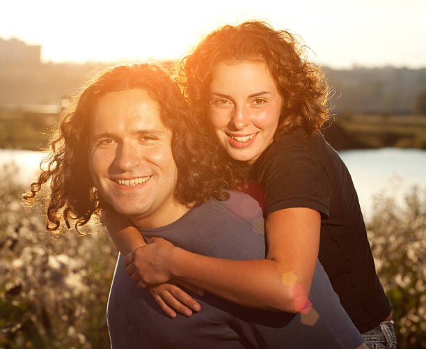 feliz pareja - lifestyles long hair curly hair spooning fotografías e imágenes de stock