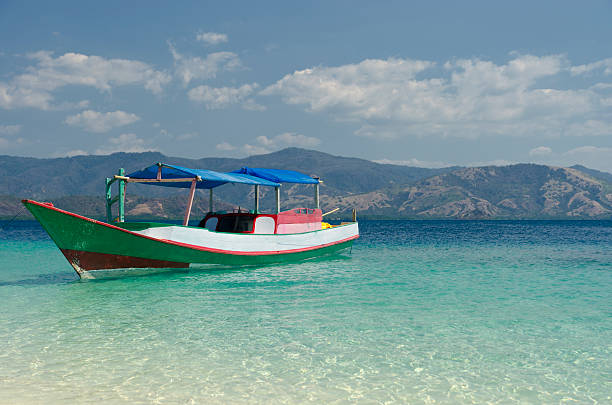 A fishing boat anchored on turquoise waters of Indonesia. Copy space on right.See also