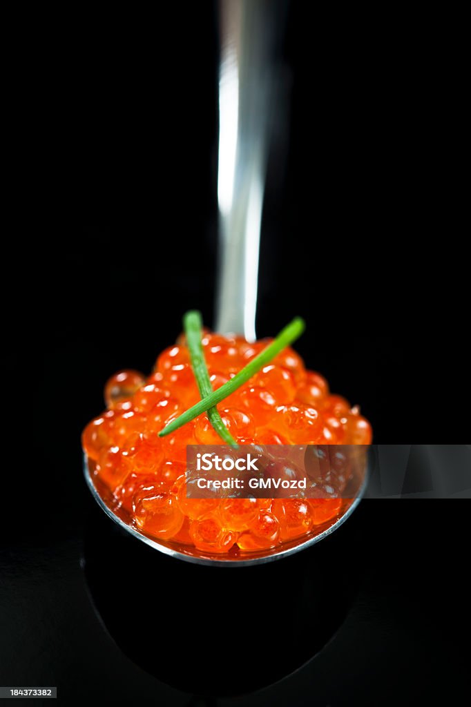 Red Caviar The spoon of  red caviar on black Black Background Stock Photo