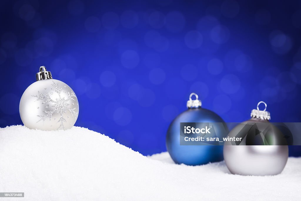 Argent et bleu décorations de Noël sur la neige, fond bleu - Photo de Blanc libre de droits