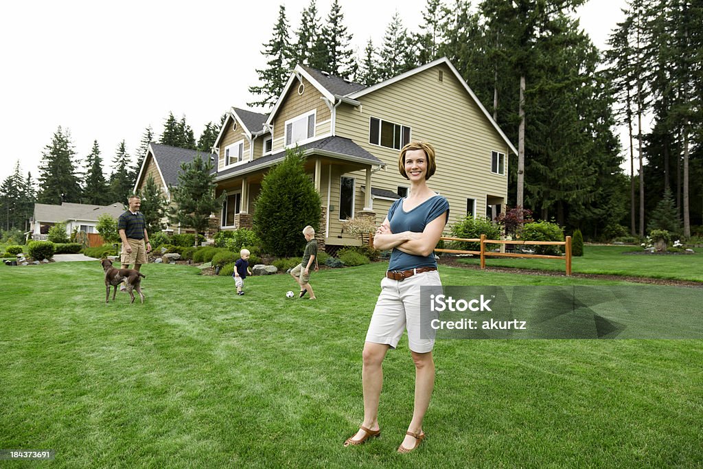 Família de quatro casa com mamãe feliz orgulhosa - Foto de stock de Jardim particular royalty-free