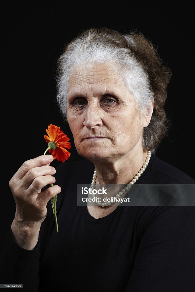 Smell Old woman holding colorful and fresh flower Aging Process Stock Photo