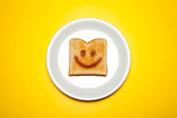 Concept photograph of a toasted toast on a plate and yellow background.