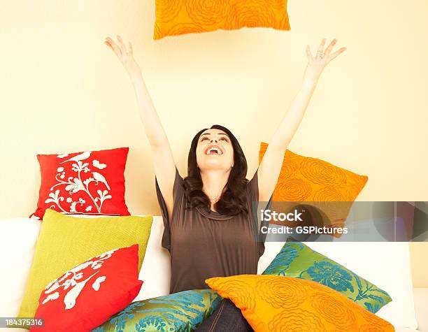 投げる若い女性の枕のリビングルーム - 沢山の物のストックフォトや画像を多数ご用意 - 沢山の物, 枕, 1人