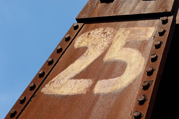 istock Rusty number 25 and a row of big screws 184375736
