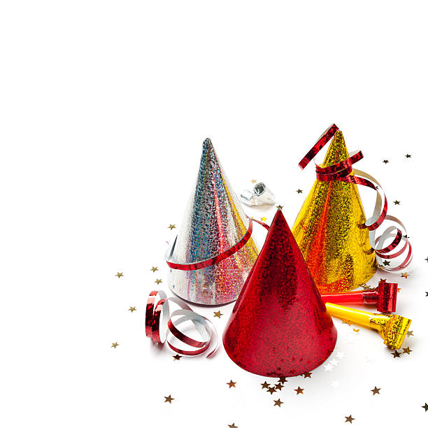 Party decorations: hats, whistles, streamers, confetti on white background. Square composition, copy space, studio shot.