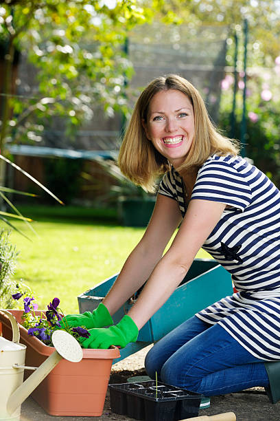 Active Housewife/ Woman Kneeling While Gardening A portrait of an active housewife/ woman enjoying gardening. kneelers stock pictures, royalty-free photos & images