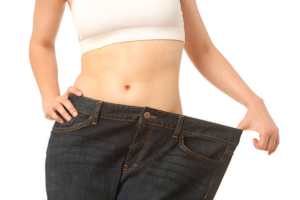 Torso of skinny woman in overweight jeans stock photo