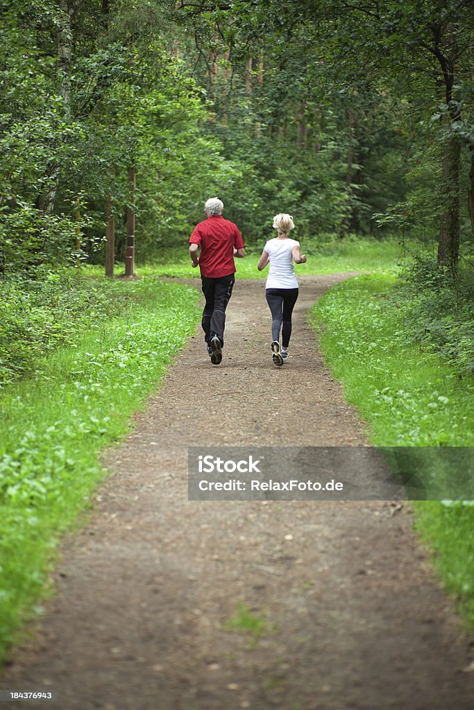 Vue arrière du couple de personnes âgées jogging dans la forêt - Photo de Courir libre de droits
