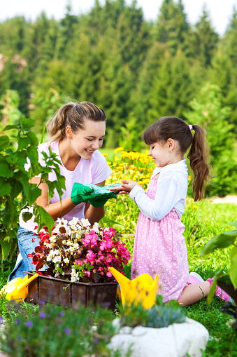 Mother and daughter planting flowers in the garden.View other gardening photos and videos in my portfolio: