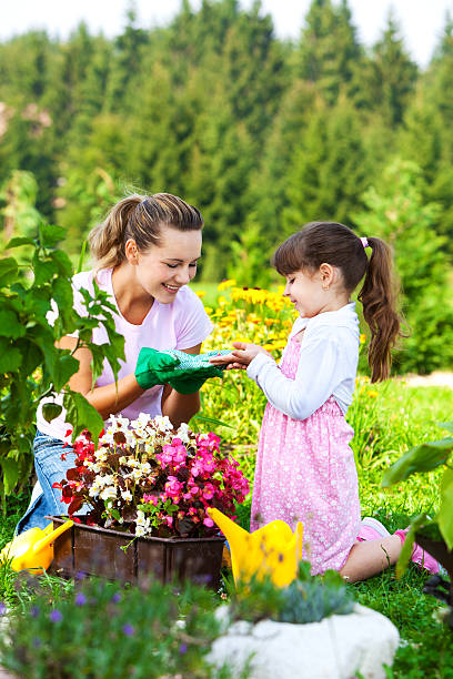 mãe e filha trabalhando no jardim - mother family vertical flower - fotografias e filmes do acervo