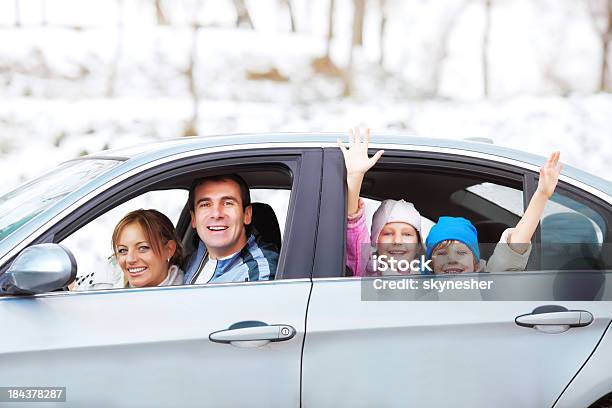Foto de Uma Família Feliz Em Um Carro Contra Um Pano De Fundo De Neve e mais fotos de stock de Família
