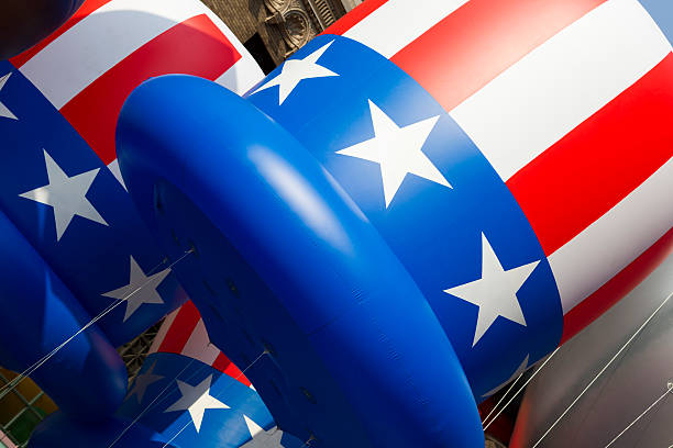 Lining the sidewalk, the American flags are waving in the wind on Fourth of July.