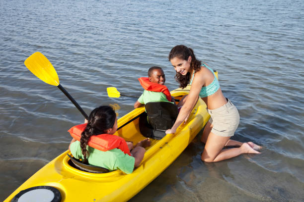 istock Camp counselor with children in kayak 184378962
