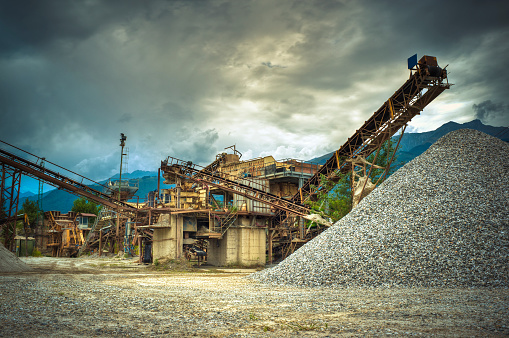 Gravel piles and factory against  cloudscape, HDR. 