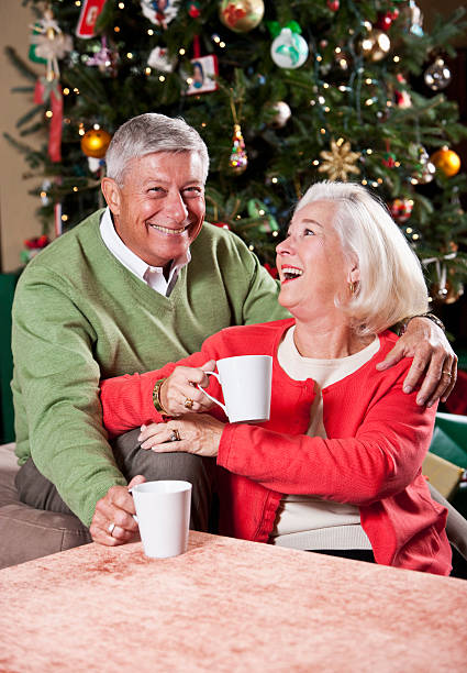 istock Senior couple relaxing by Christmas tree drinking hot chocolate 184379380