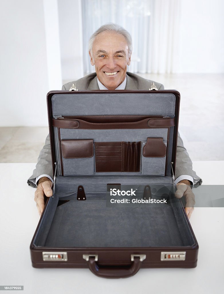 Un hombre de negocios mostrando un vacío maletín - Foto de stock de 60-69 años libre de derechos