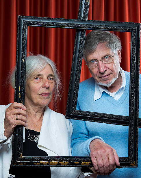 istock Senior couple holding picture frames 184379793