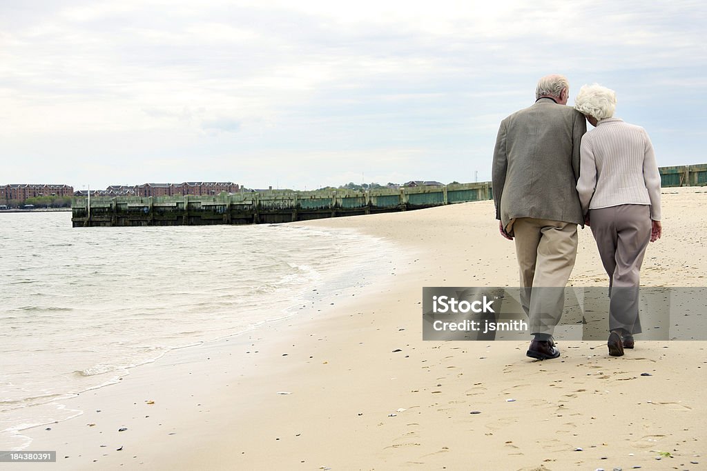 Starsza para Trzymać się za ręce i spacery na plaży - Zbiór zdjęć royalty-free (Od tyłu)
