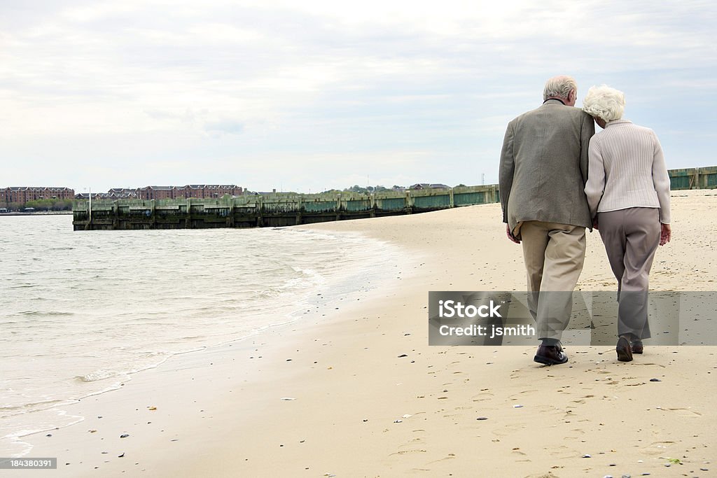 Casal Idoso de mãos dadas e a caminhar pela praia - Royalty-free Andar Foto de stock