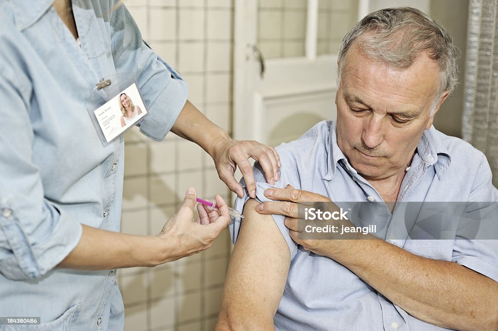 El personal de enfermería que la vacunación hombre - Foto de stock de Protección libre de derechos