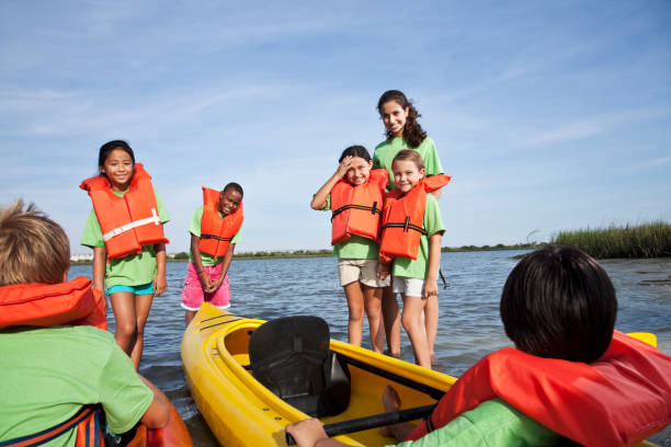 istock Summer camp counselor and children with kayaks 184380781