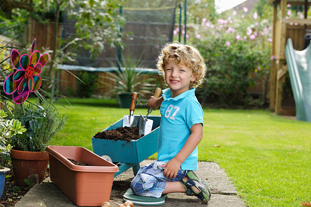 Portrait Of Cute Toddler/ Little Boy Gardening A portrait of a cute toddler/ little boy gardening kneelers stock pictures, royalty-free photos & images
