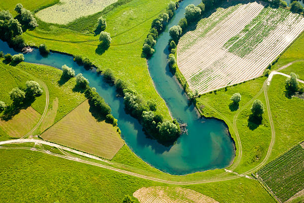 Farmland patchwork, aerial view Aerial photo of curvy river and patchwork of farmland. patchwork landscape stock pictures, royalty-free photos & images