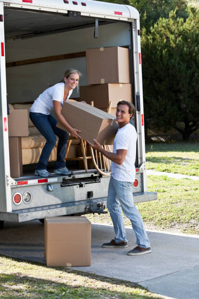 istock Young couple with moving van in driveway 184382063