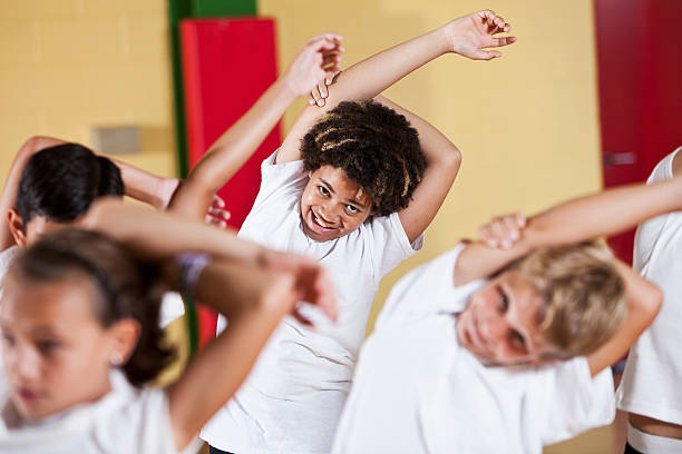 istock Group of children in phys ed class stretching 184382168
