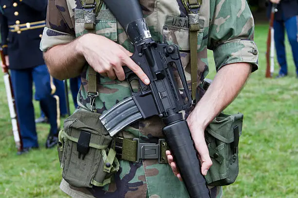 An American soldier wearing the uniform worn during the Vietnam conflicts and holding an M16 rifle.