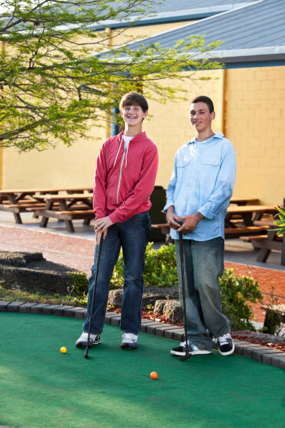 istock Teenage boys playing miniature golf 184382954