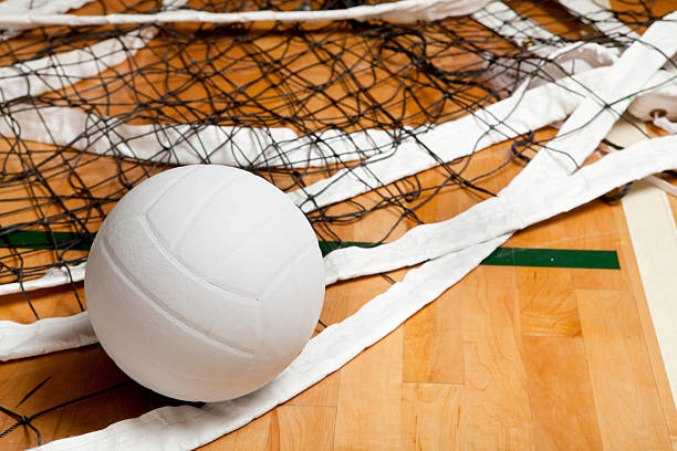 Close-up of volleyball in net on gym floor stock photo